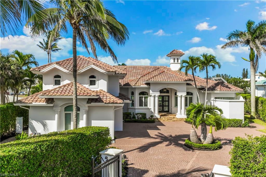 Mediterranean / spanish house with decorative driveway, stucco siding, and french doors