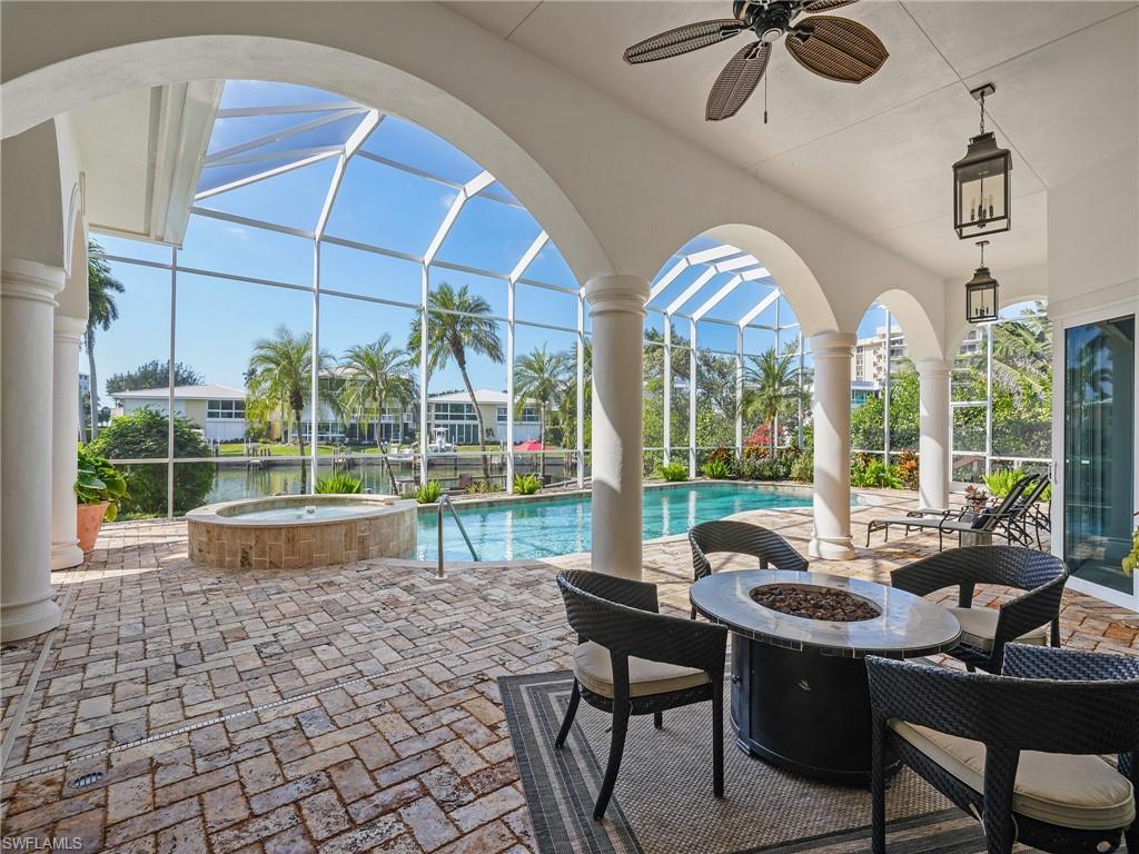 View of patio / terrace featuring an outdoor fire pit, a lanai, a sunroom, and ceiling fan