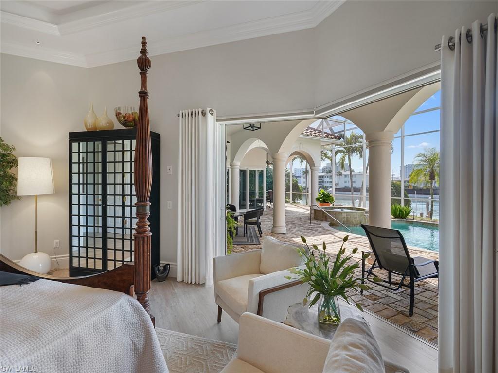 Bedroom with access to outside, wood finished floors, and crown molding