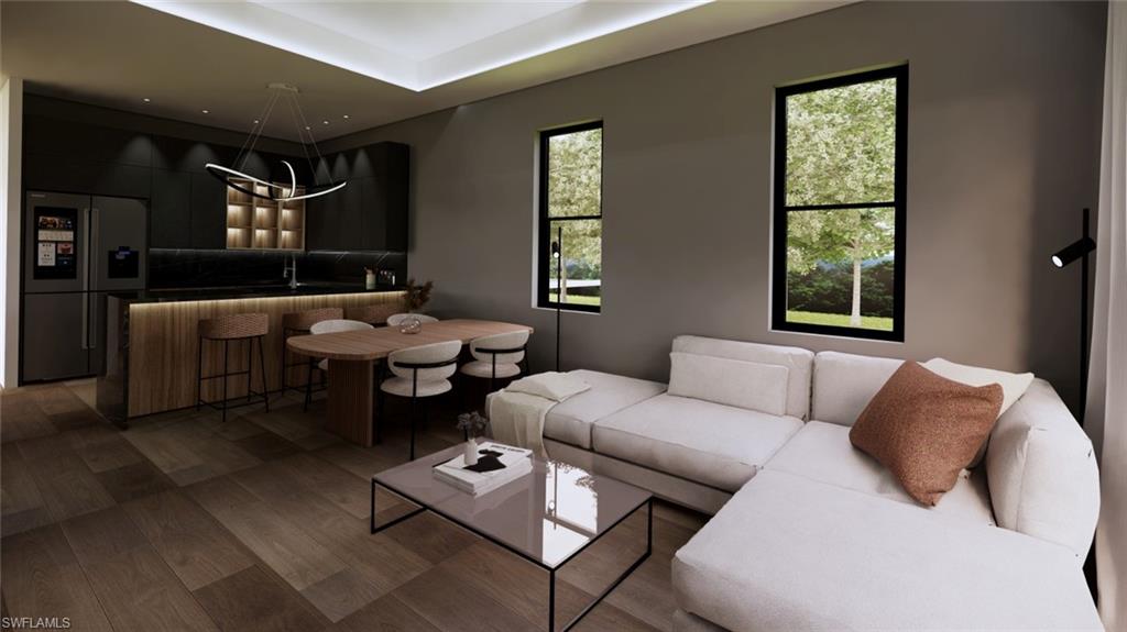Living room with wood finished floors and a tray ceiling