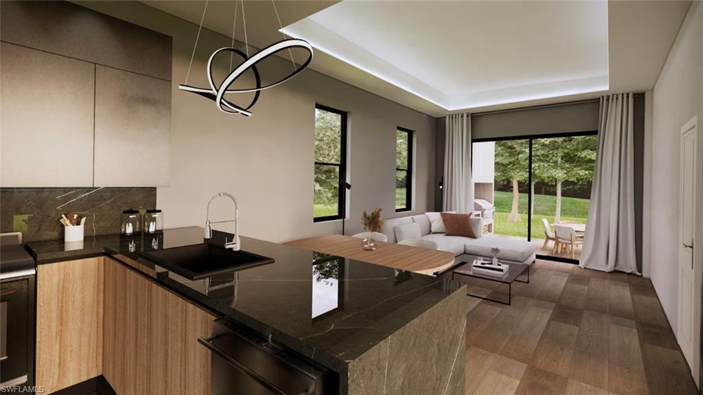 Kitchen featuring dark stone countertops, a raised ceiling, tasteful backsplash, dark wood finished floors, and a chandelier