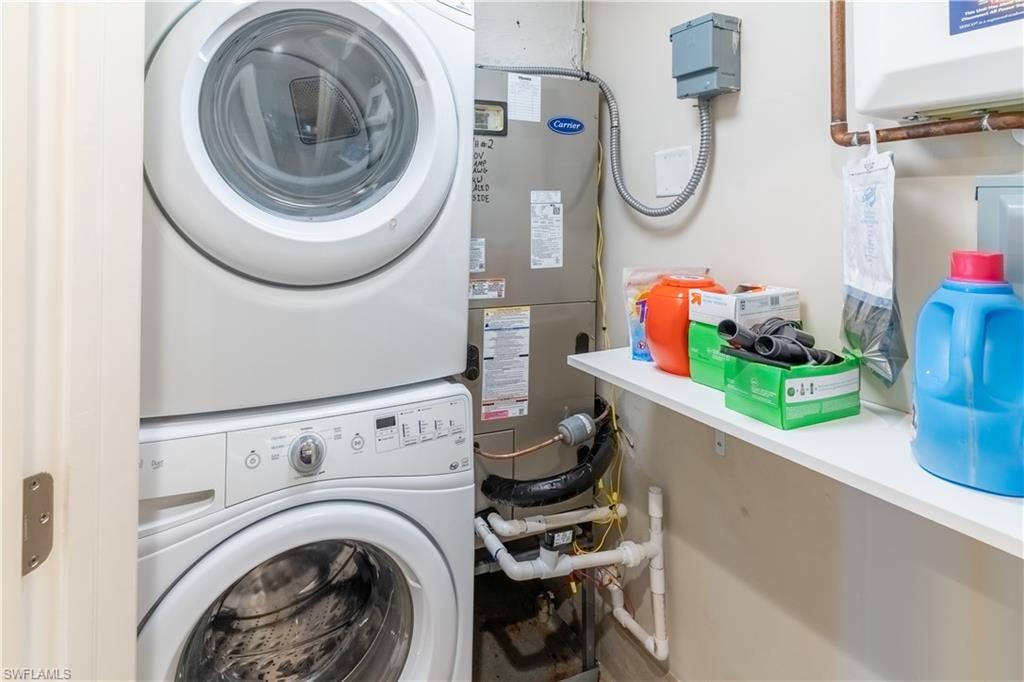 Laundry room featuring estacked washer and dryer and heating unit