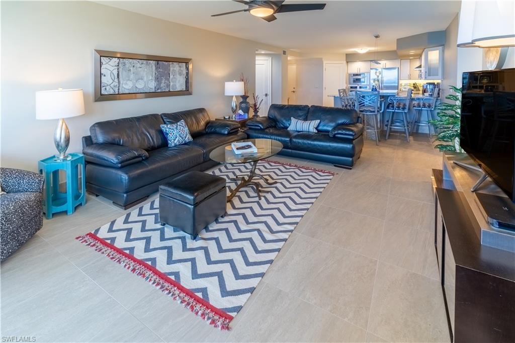 Living area featuring ceiling fan and light tile patterned floors