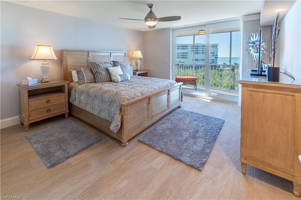 Bedroom with a wall of windows, ceiling fan, access to outside, and light wood-type flooring