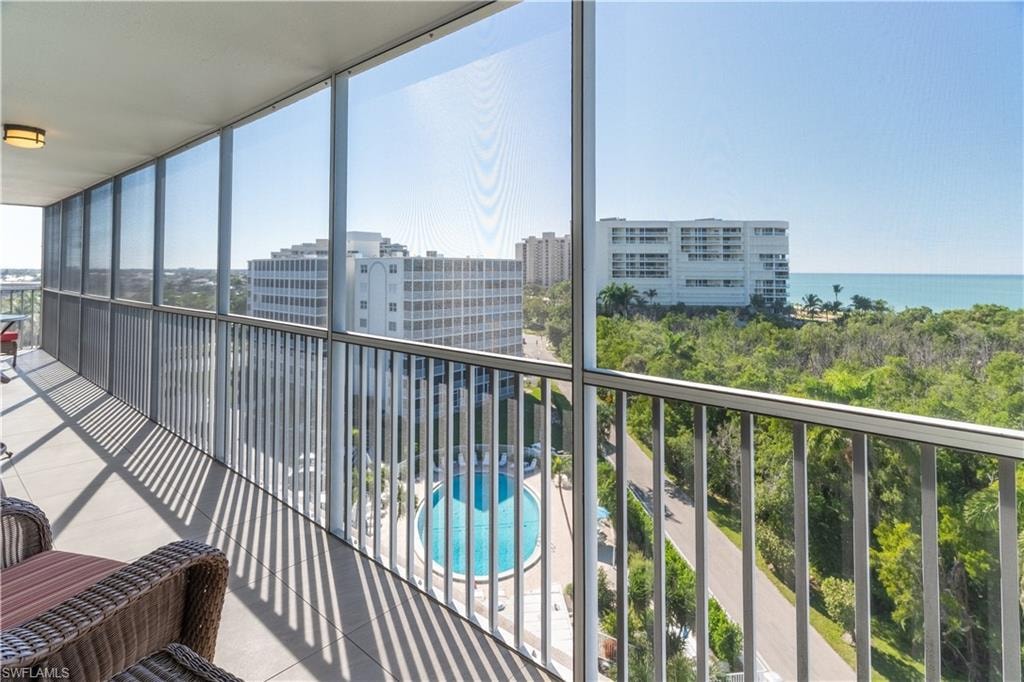 Balcony with a sunroom and view of pool area