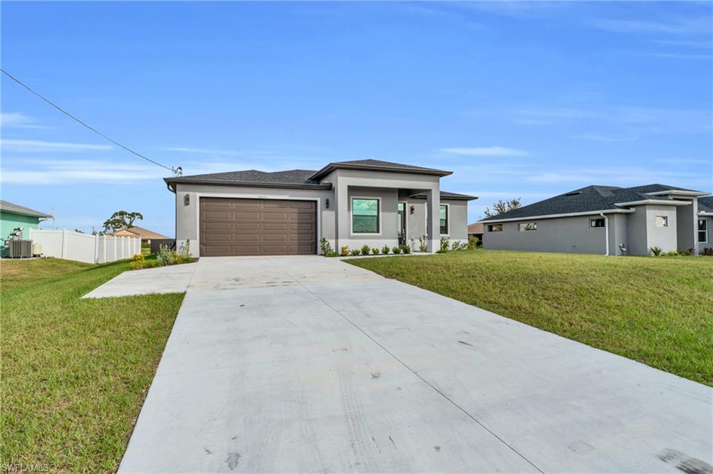Prairie-style home with stucco siding, driveway, and a garage
