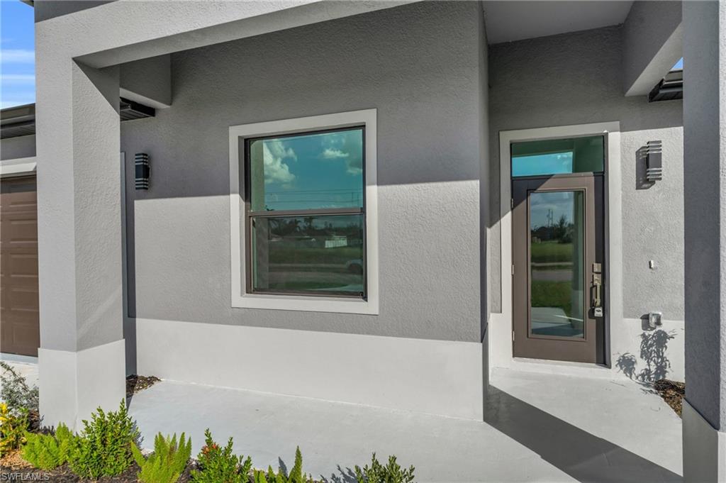 View of exterior entry featuring stucco siding