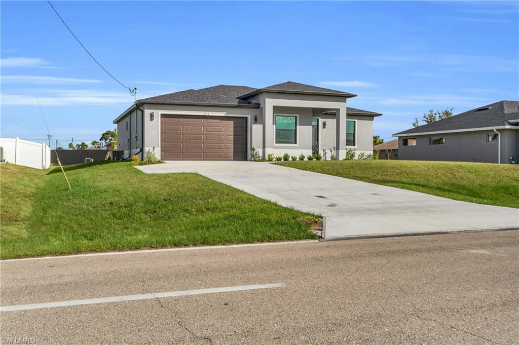 Prairie-style house featuring stucco siding, driveway, and a garage