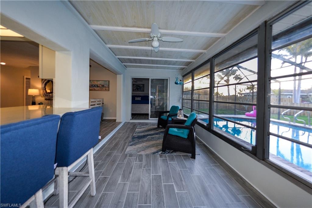 Original Florida Room furnished with wood ceiling and porcelain tile flooring - Sliders to primary suite