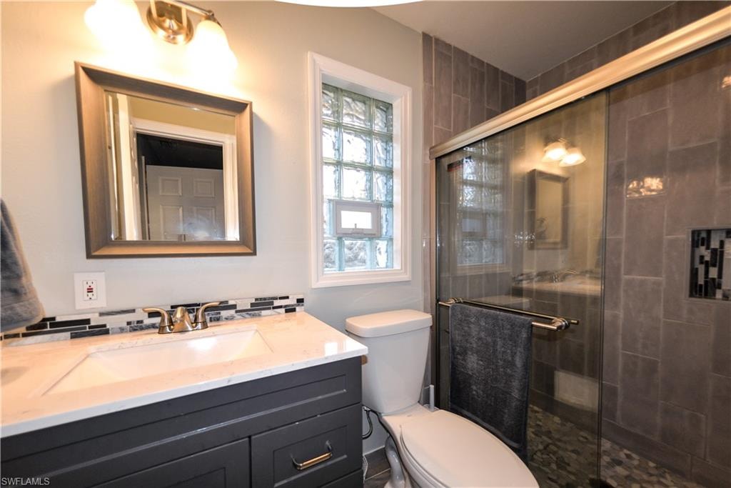 primary en-suite with porcelain tile - quartz - and glass block window