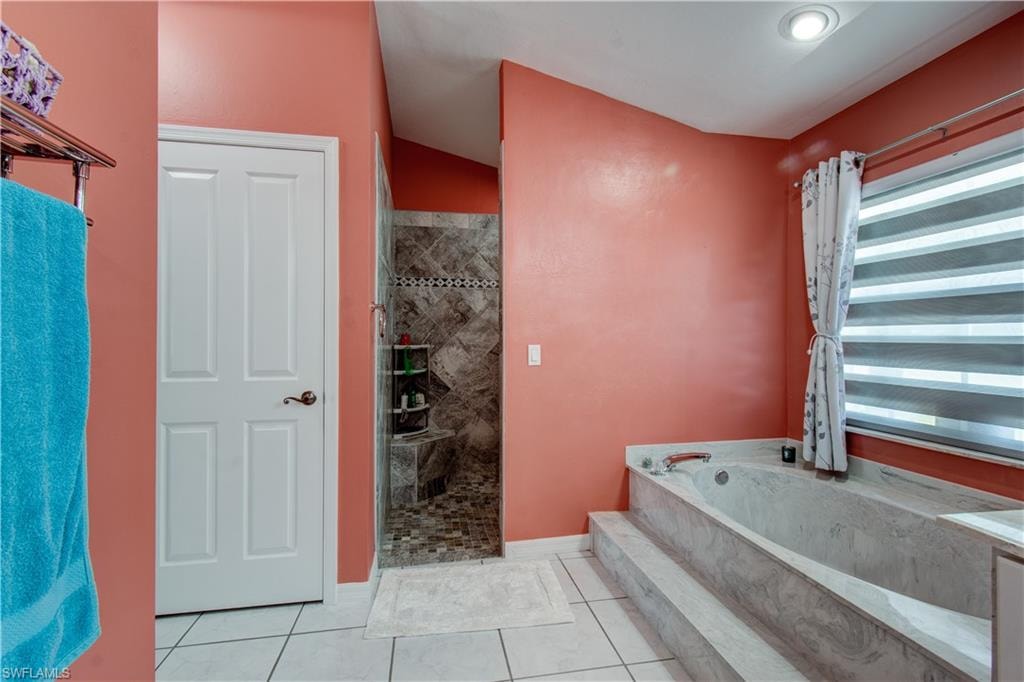 Full bath featuring a bath, a shower stall, and light tile patterned flooring