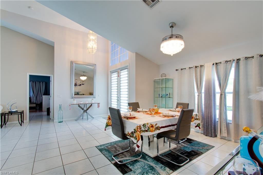 Dining space with light tile patterned flooring and a high ceiling