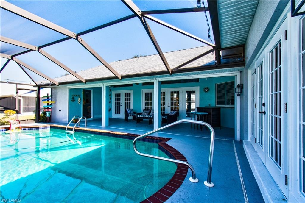Outdoor pool with french doors, glass enclosure, a sunroom, and a patio