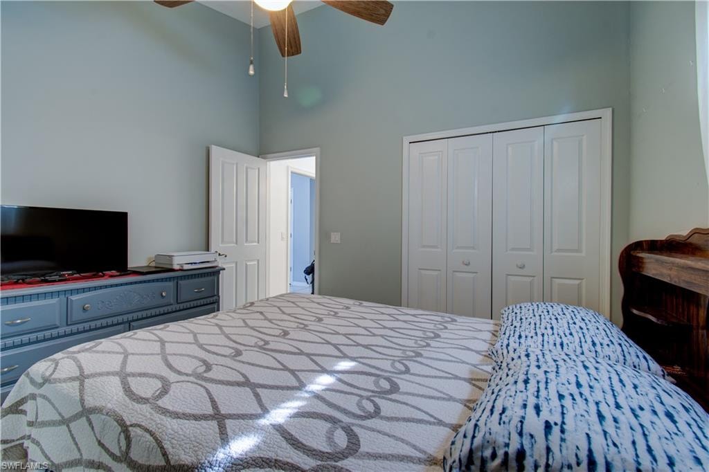 Bedroom with a towering ceiling, a closet, and ceiling fan