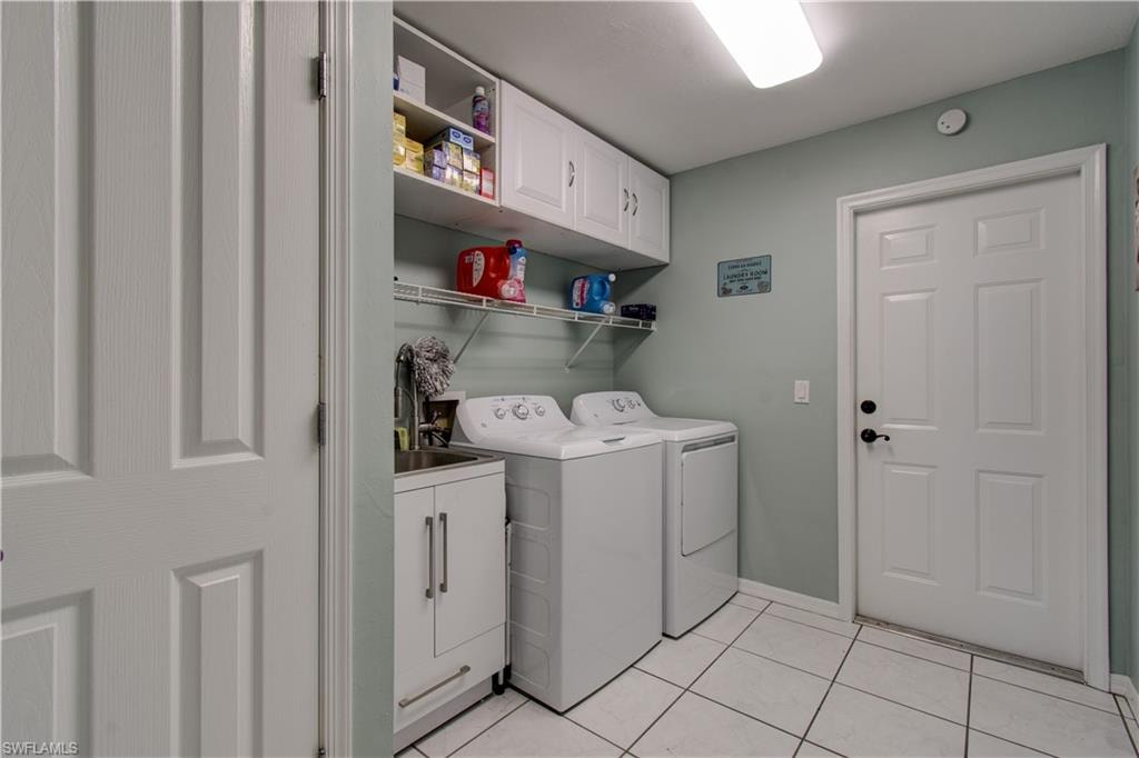 Laundry room featuring cabinet space, washing machine and clothes dryer, and light tile patterned floors