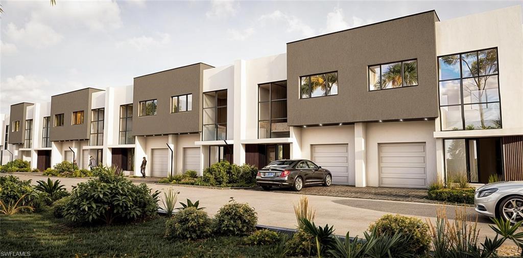 View of property with decorative driveway and an attached garage