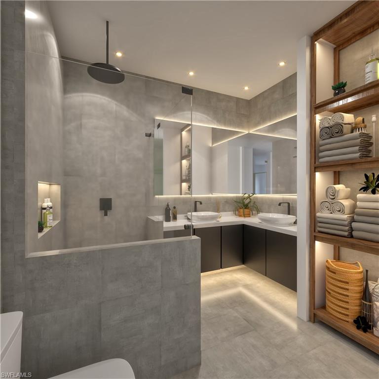 Bathroom featuring double vanity, a walk in shower, and recessed lighting