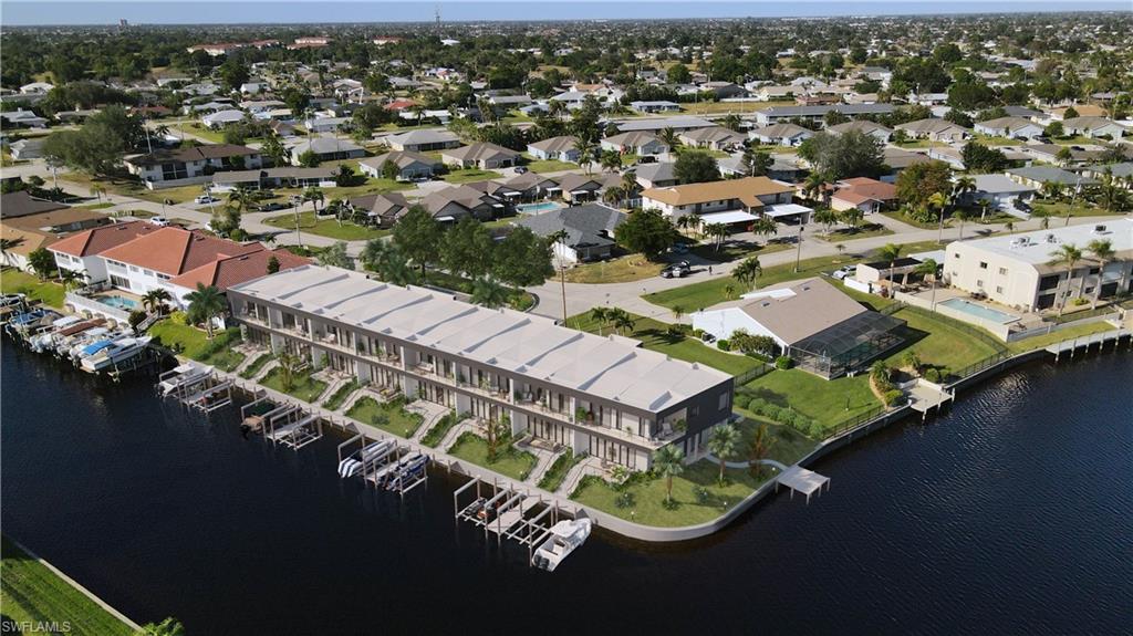 Aerial view of property and surrounding area featuring a nearby body of water