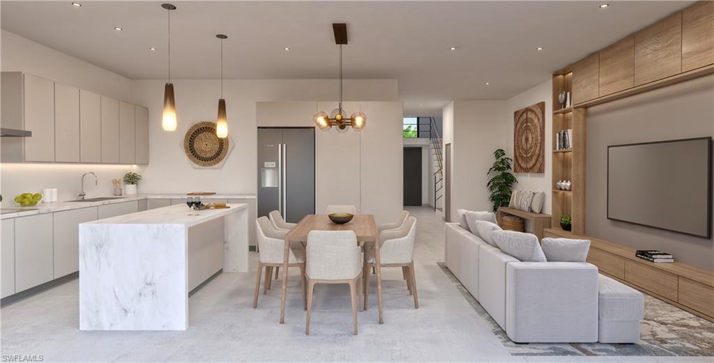 Kitchen with modern cabinets, decorative light fixtures, a kitchen island, high end refrigerator, and open floor plan