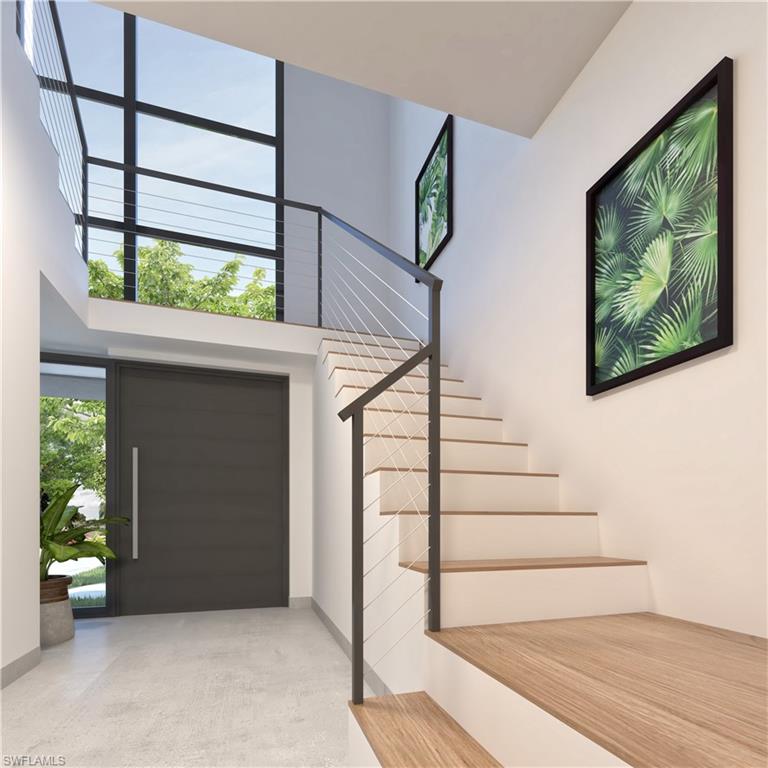 Entrance foyer with a high ceiling, stairway, and concrete flooring