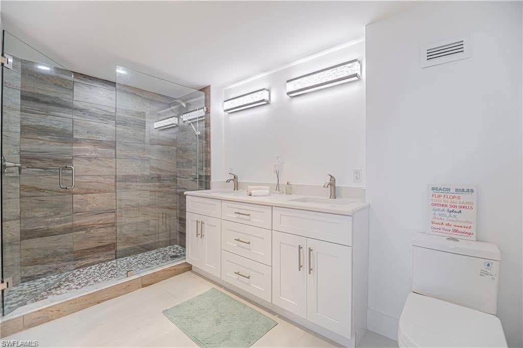 Full bath with double vanity and a spa like walk-in shower