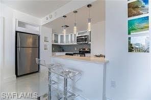 Modern kitchen with white cabinetry, island seating, stainless steel appliances