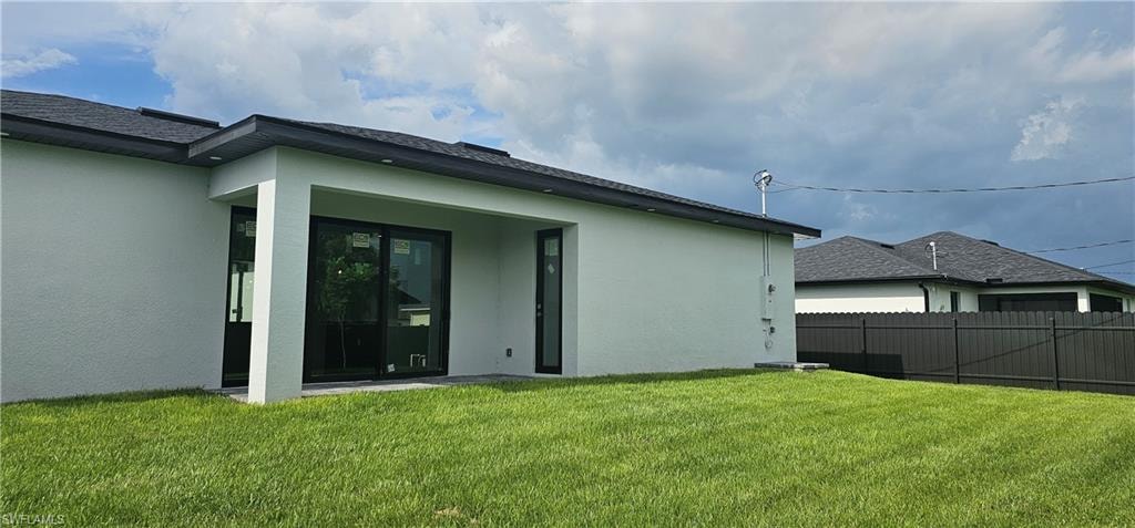 Back of house with stucco siding and a patio