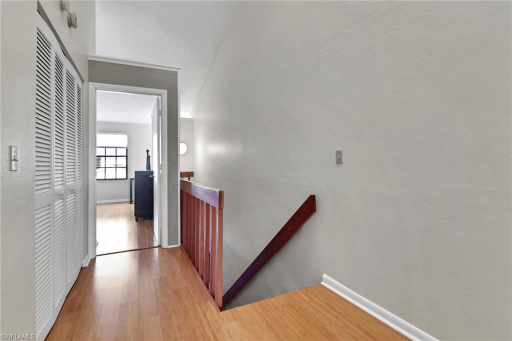 Hallway with an upstairs landing and wood finished floors