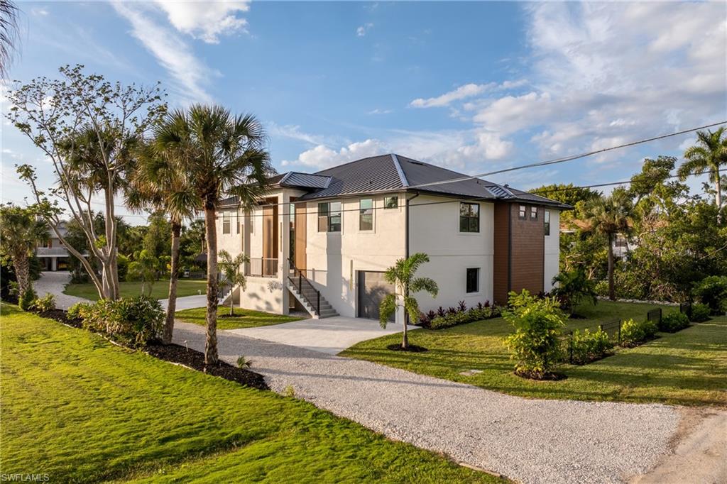 Contemporary home with driveway, a front yard