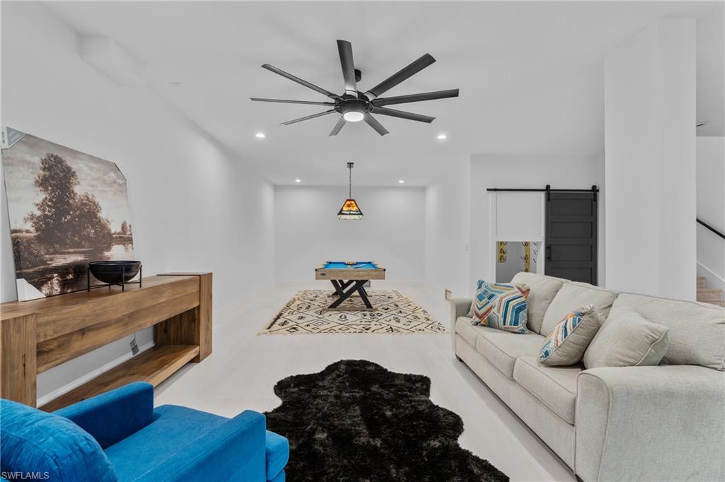 Living room featuring a barn door, ceiling fan, billiards, and recessed lighting
