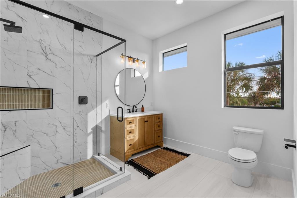 Full bathroom with a marble finish shower, vanity, recessed lighting, and light tile patterned floors