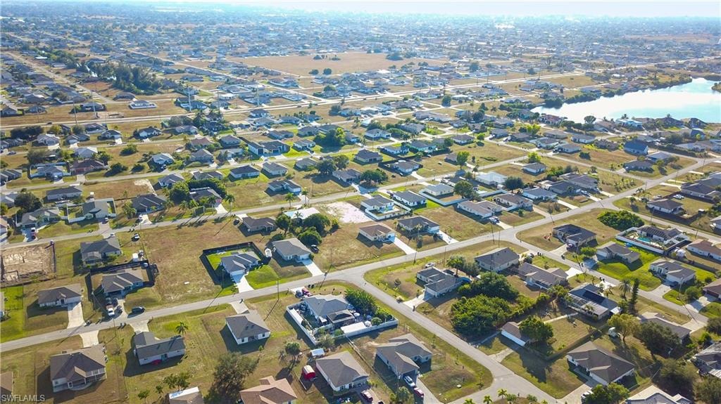 Aerial view of property and surrounding area featuring nearby suburban area