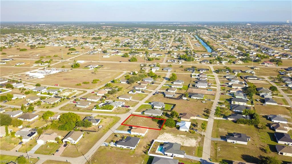Aerial view of property and surrounding area featuring nearby suburban area and property boundaries highlighted