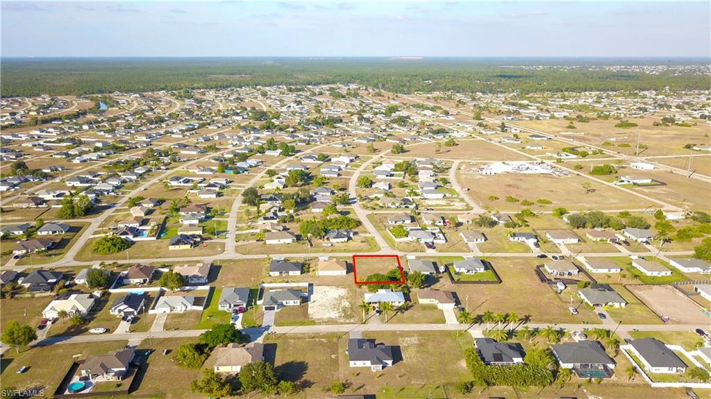 Aerial view of property's location with nearby suburban area and property parcel outlined