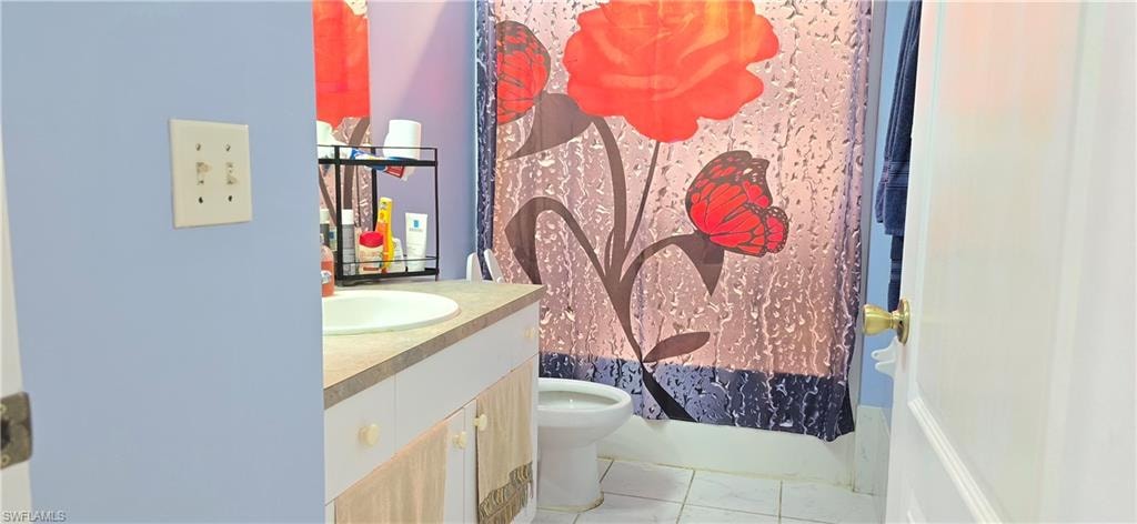 Bathroom featuring vanity and shower / bathtub combination with curtain