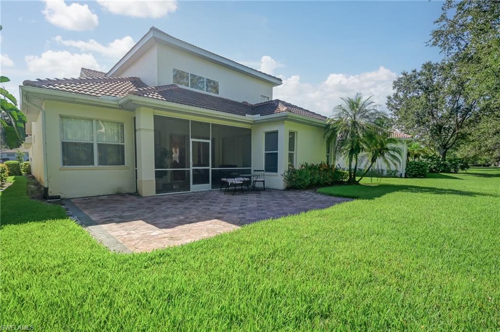 Rear view of house with a patio, stucco siding, and a yard