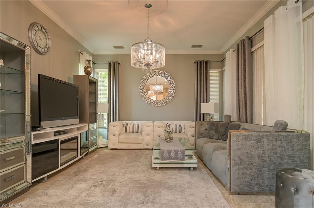 Living area with crown molding and a chandelier