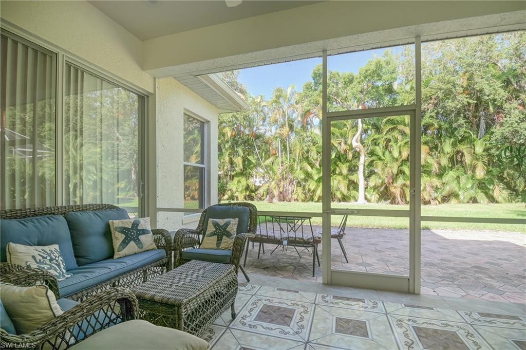 Sunroom / solarium featuring view of scattered trees