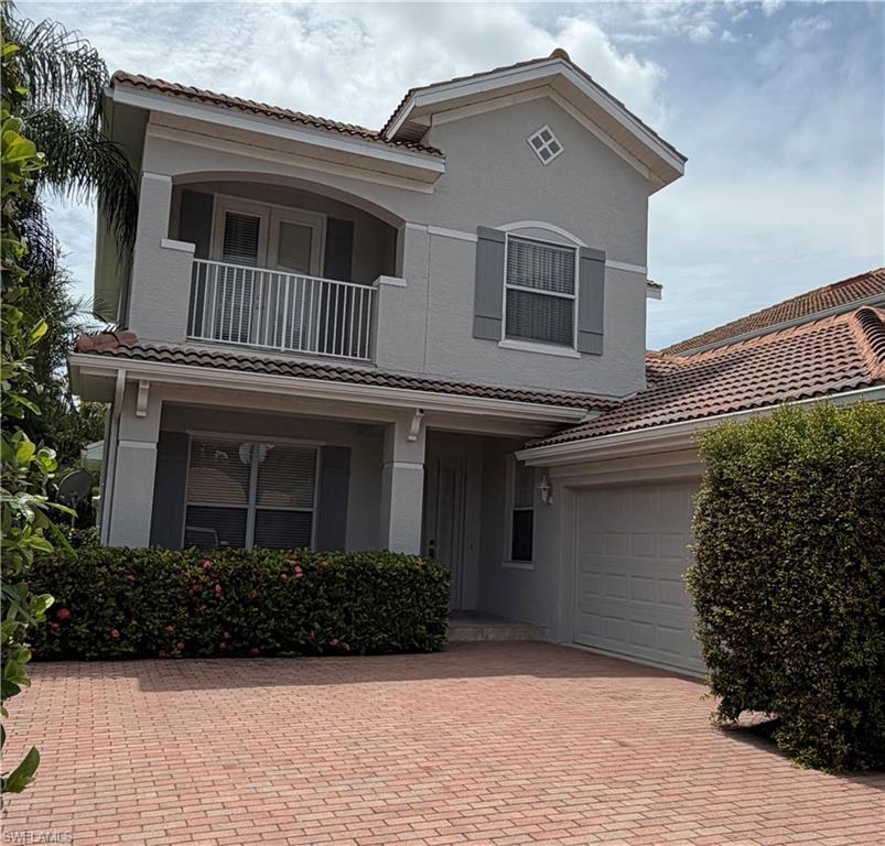 Mediterranean-inspired exterior with a two-story stucco facade, red barrel tile roof, and an integrated garage