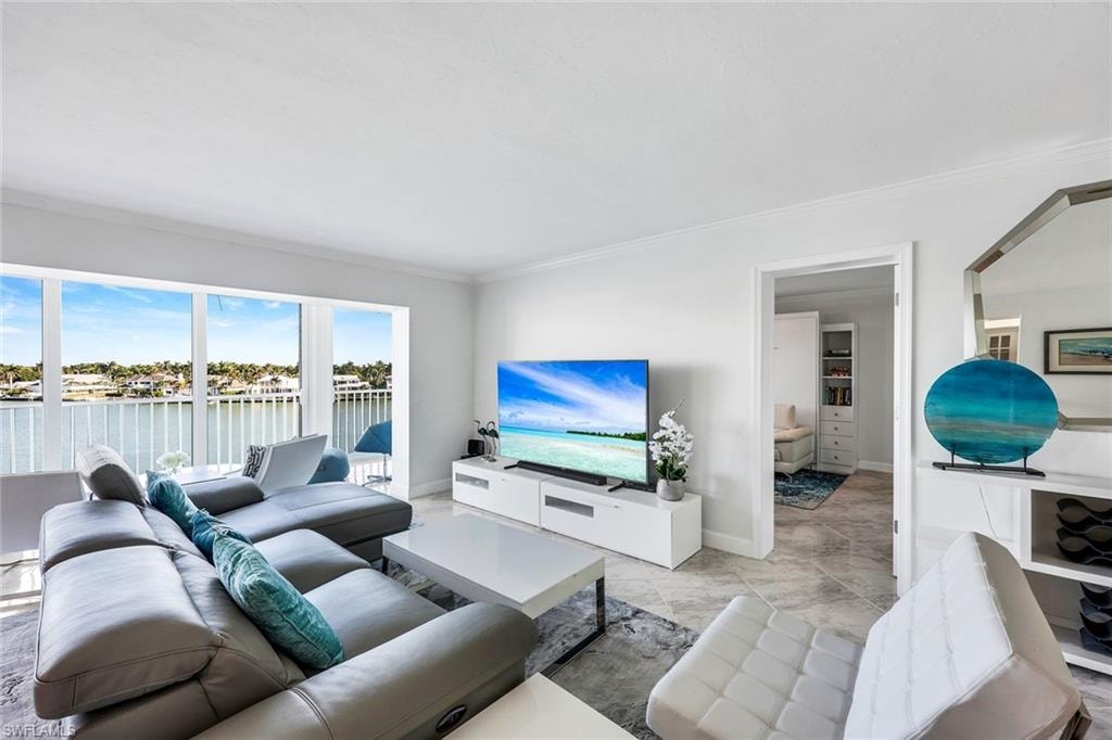 Living room with ornamental molding and baseboards