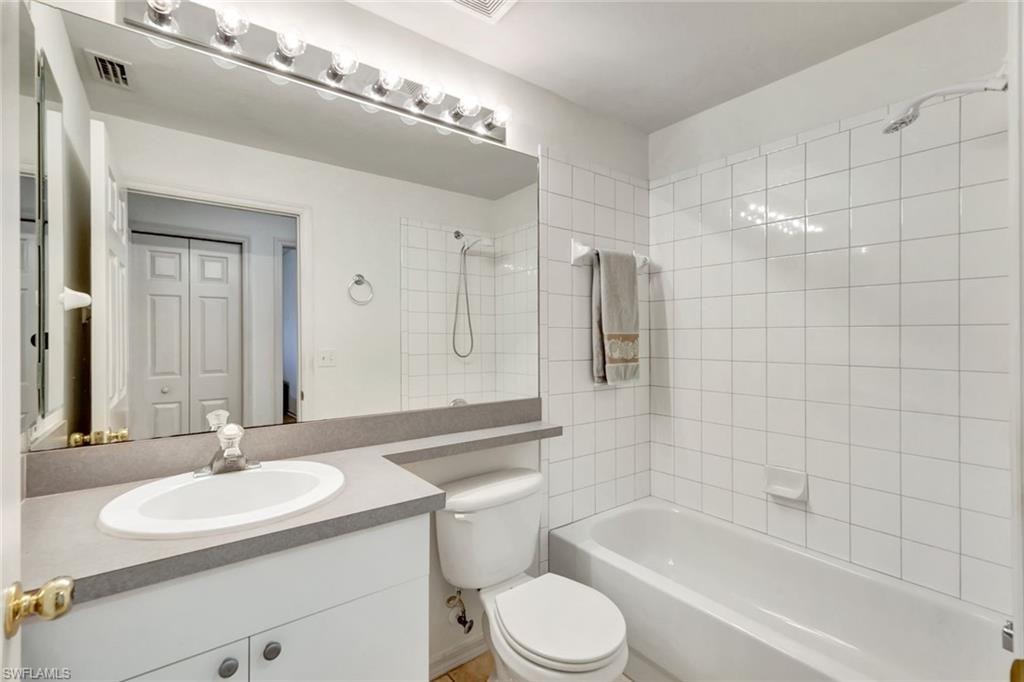 Bathroom with visible vents, shower / bathing tub combination, vanity, and toilet