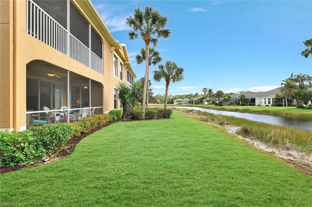 View of yard featuring a water view and a sunroom