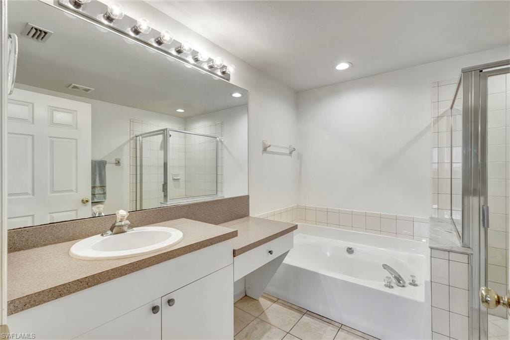 Full bathroom featuring a garden tub, tile patterned flooring, vanity, visible vents, and a shower stall