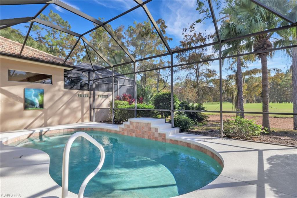 Swimming pool with glass enclosure, a sunroom, view of golf course, and a patio