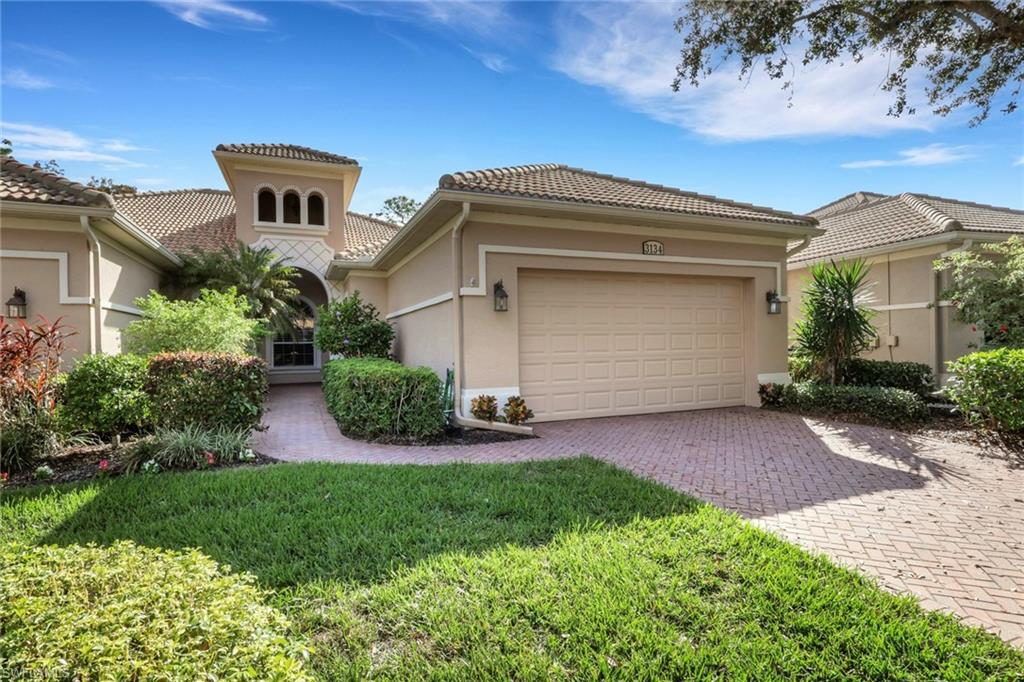 Mediterranean / spanish-style home with stucco siding, a front yard, decorative driveway, and an attached garage