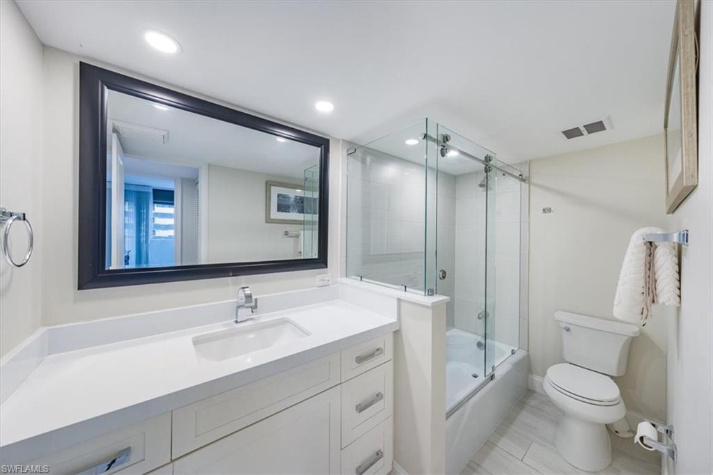 Full bath featuring vanity, bath / shower combo with glass door, and recessed lighting