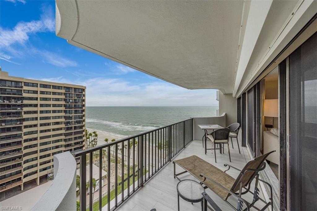 Balcony featuring view of water and beach
