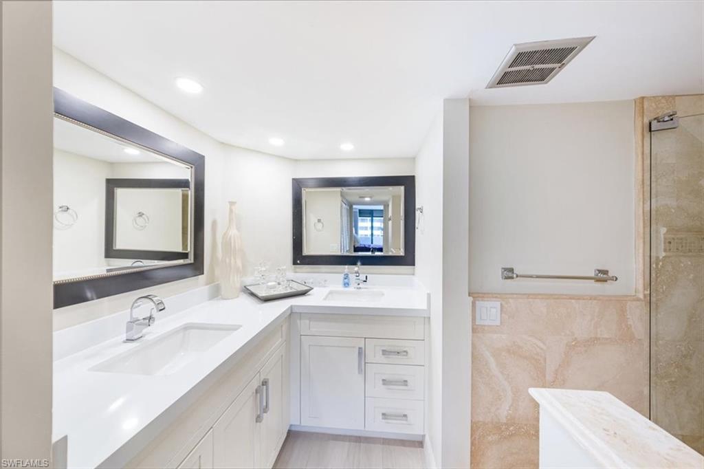 Bathroom with double vanity, tiled shower, recessed lighting, tile walls, and a freestanding bath