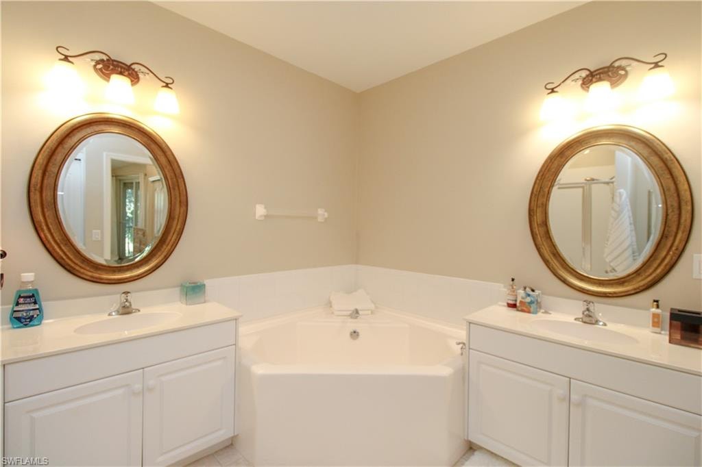 Bathroom with tile patterned flooring, a bathtub, and vanity