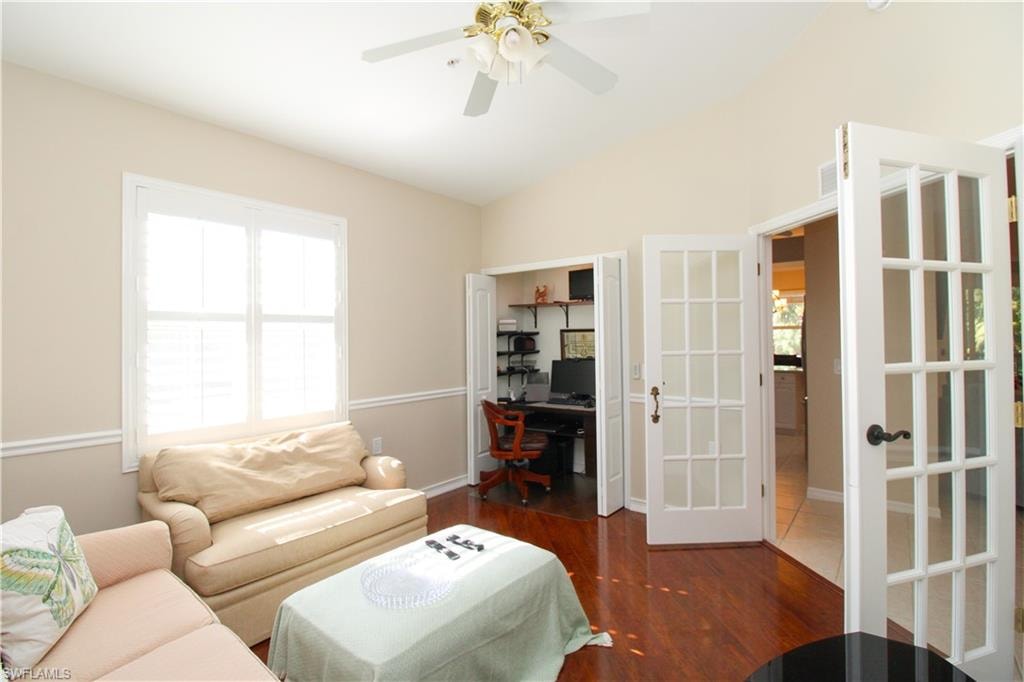 Living room featuring french doors, vaulted ceiling, ceiling fan, and dark wood-type flooring